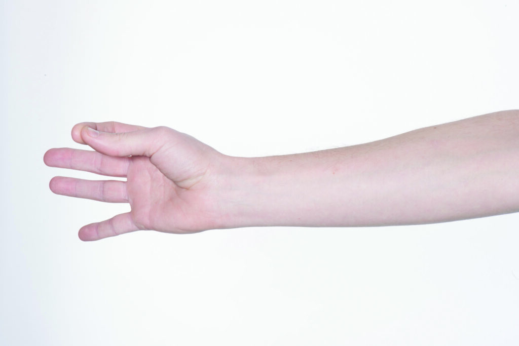 Photograph of a persons hand with fingers out stretched and thumb tapping fingers