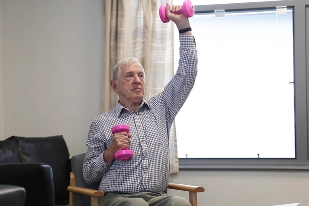 Photograph of a person doing overhead arms