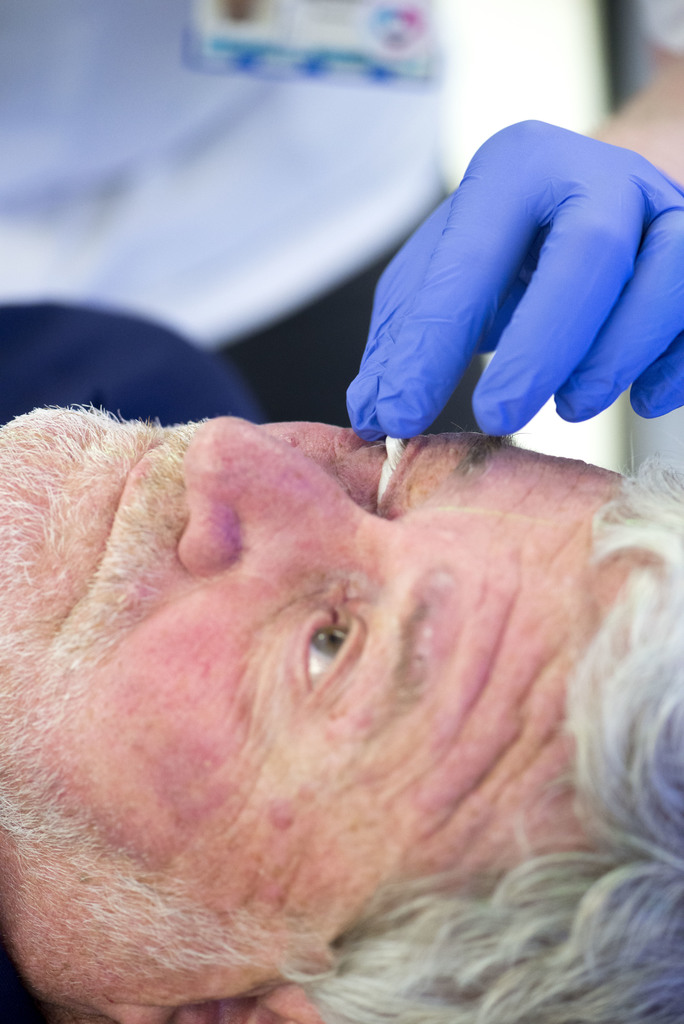 Photograph showing a clinician checking the position of the eye shield before treatment.