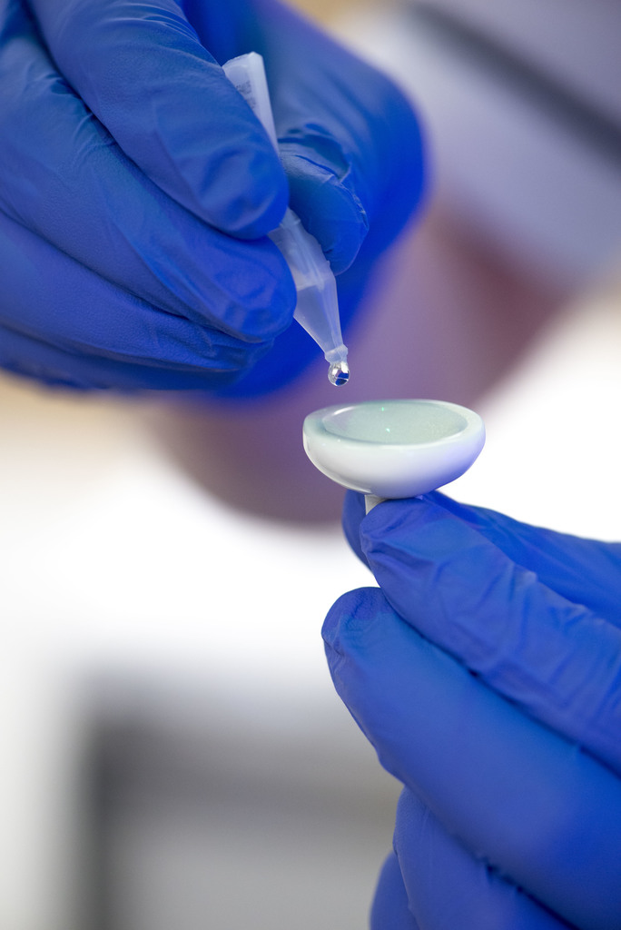 Photograph of a person dropping lubricant onto an eye shield.