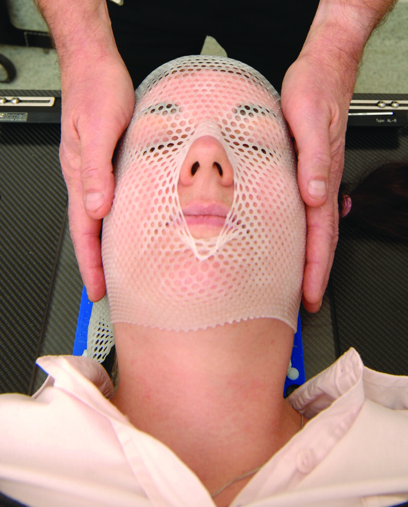 An image of a patient being fitted with a plastic mask.