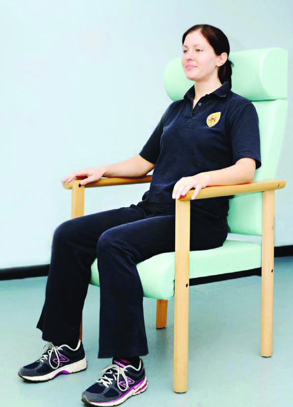 Photograph of a person sitting correctly in a chair.