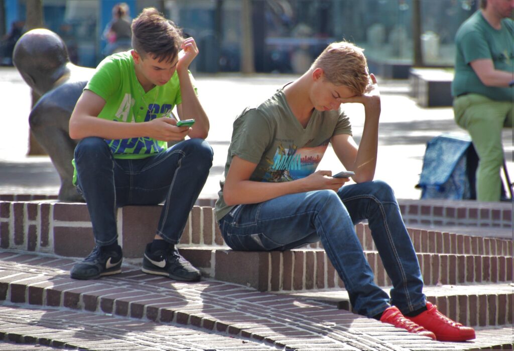 Two teenage boys on their mobile phones