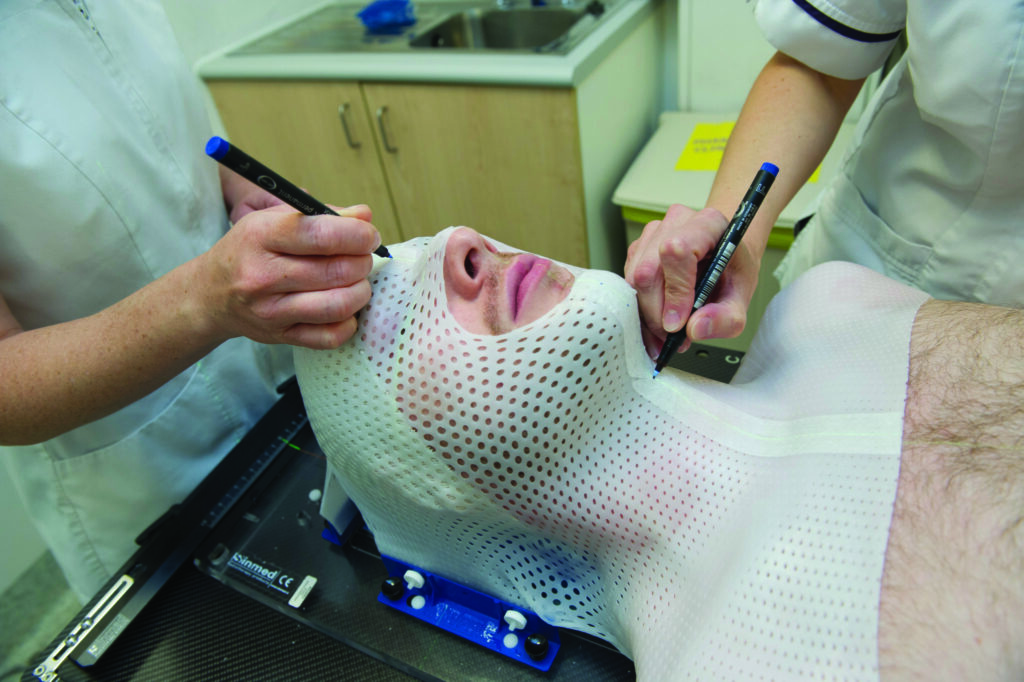 An image of a patient being fitted with a plastic mask.