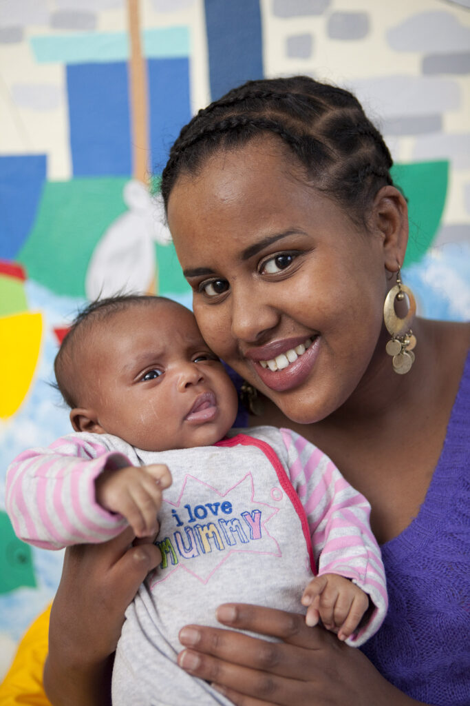 Photograph of a person holding a newborn baby