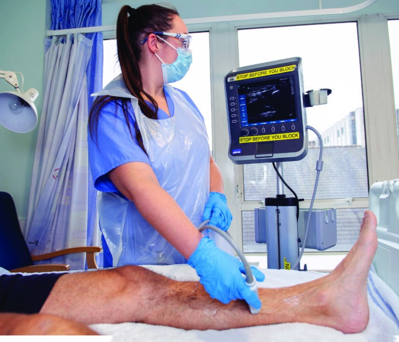 An image showing a practitioner using an ultrasound machine on a patients leg.