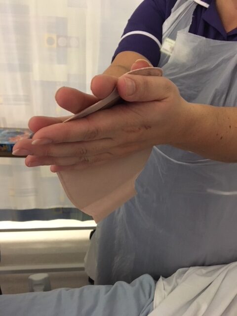 Photo showing how to warm the baseplate to help it adhere to the skin