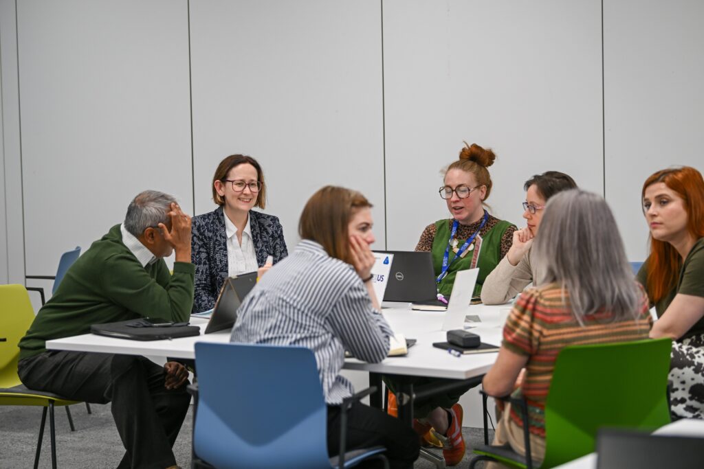 An image of Bev Riley of the Innovation Pop Up team working with the other delegates at the event.
