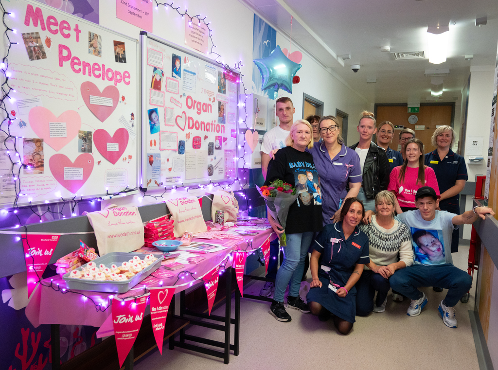 dilans family with ltht colleagues next to display for organ donation, including leaflets and information boards