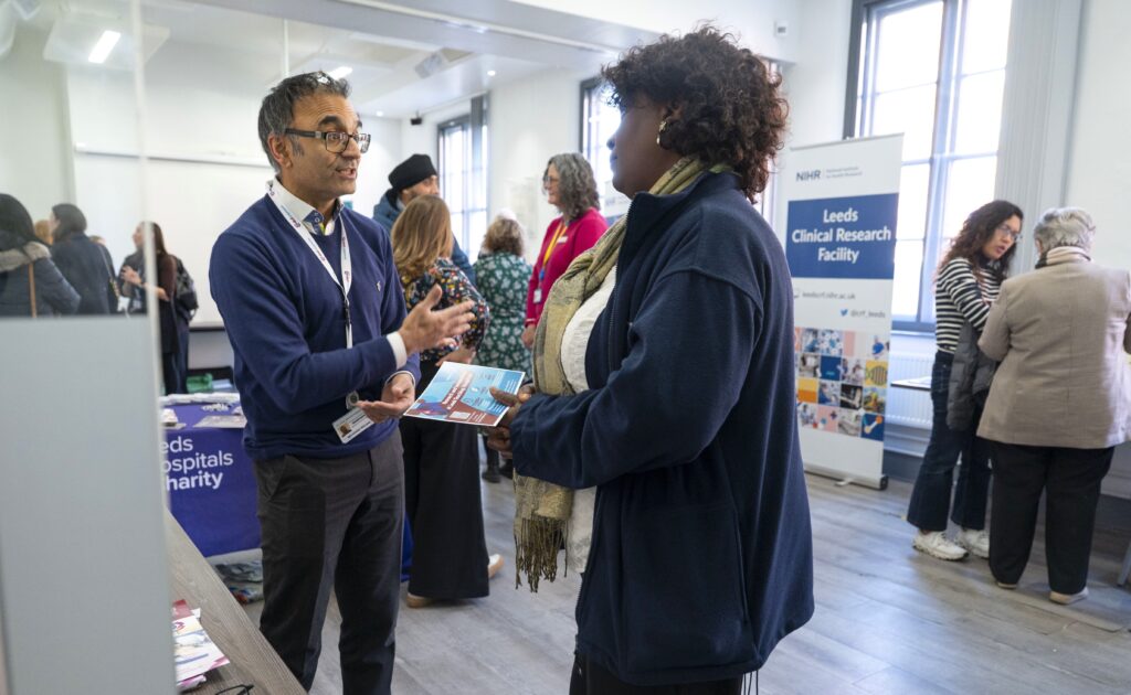 An image of the event with 2 people discussing in conversation in the foreground.