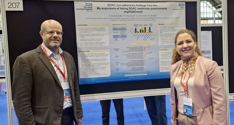 An image of Dr Rani Khatib and Dr Emma Kampouraki from the InnoMeds Team standing next to a poster of a questionnaire for the DOAC non-adherence findings from the My experience of taking DOAC medicines.