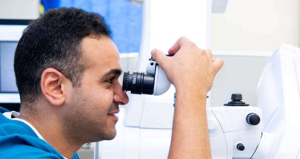 Ahmed Bardan looking through a microscope device.