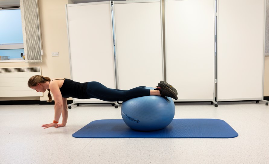 Gradually increase the distance, until you can roll the ball to your feet.