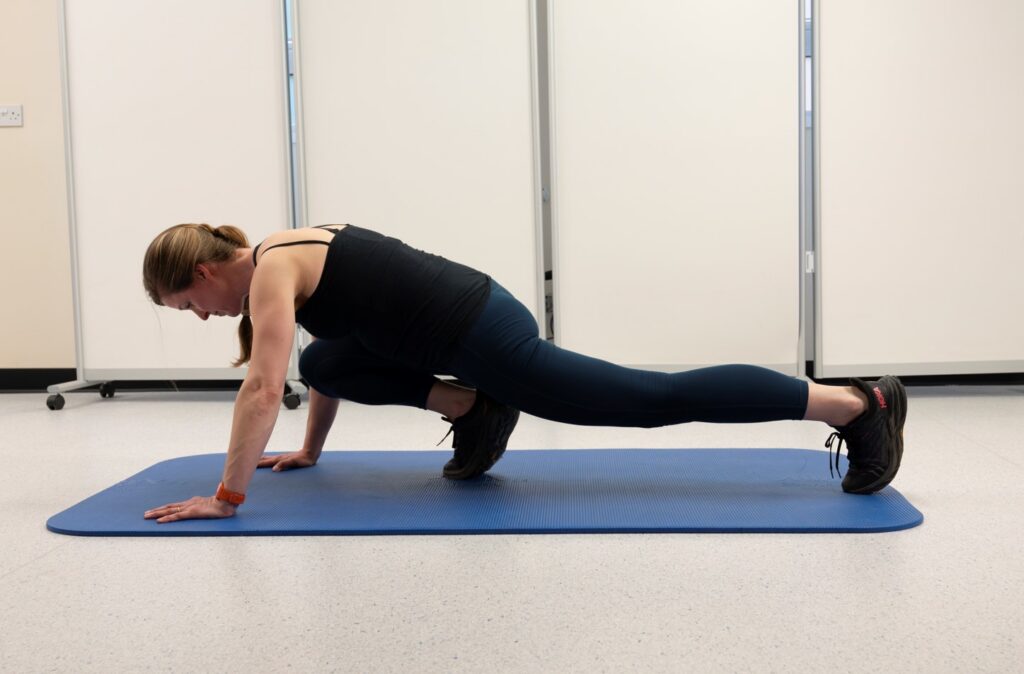 Start in a high-plank position with your hands directly under your shoulders and your body forming a straight line.