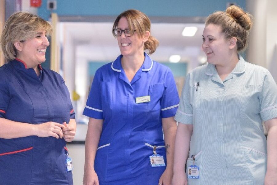 Three female clinicians talking, smiling