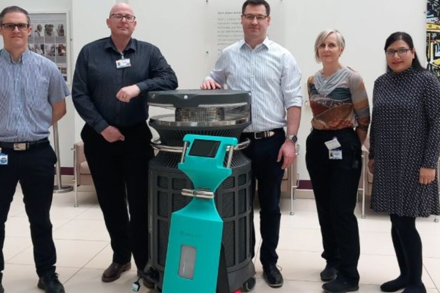 5 people smiling at the camera, stood in front of the new HPV device.