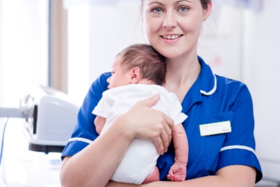 A midwife holding a baby.