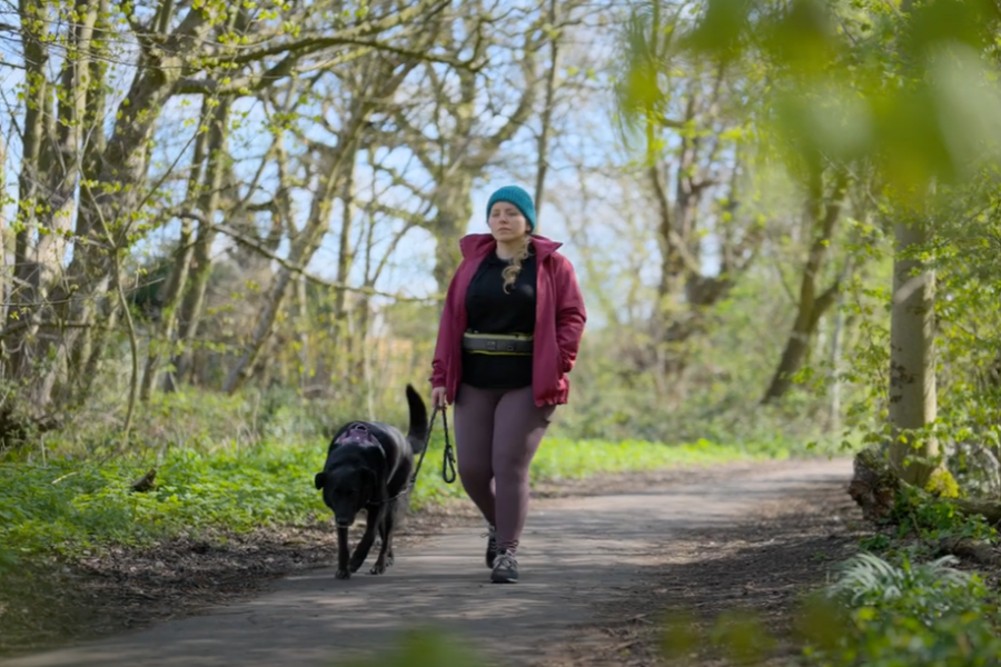 person walking dog in woods