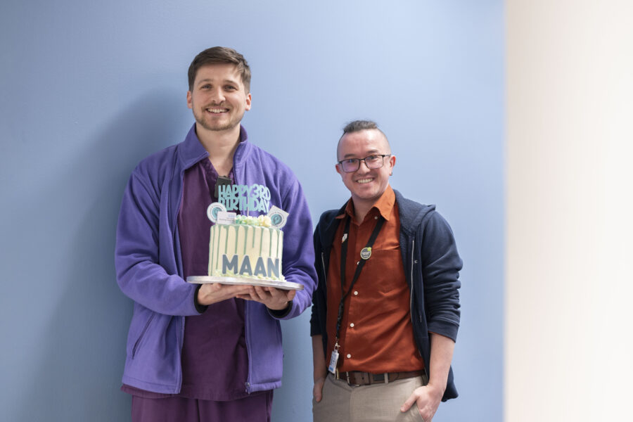 Two men holding a birthday cake