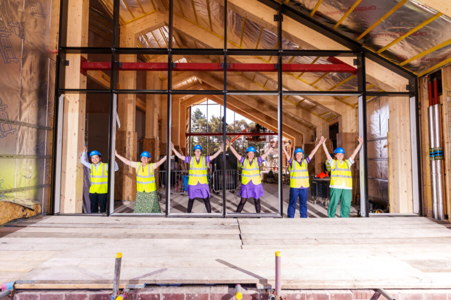 MND nurses pose inside the window frames of the new Rob Burrow Centre for MND.