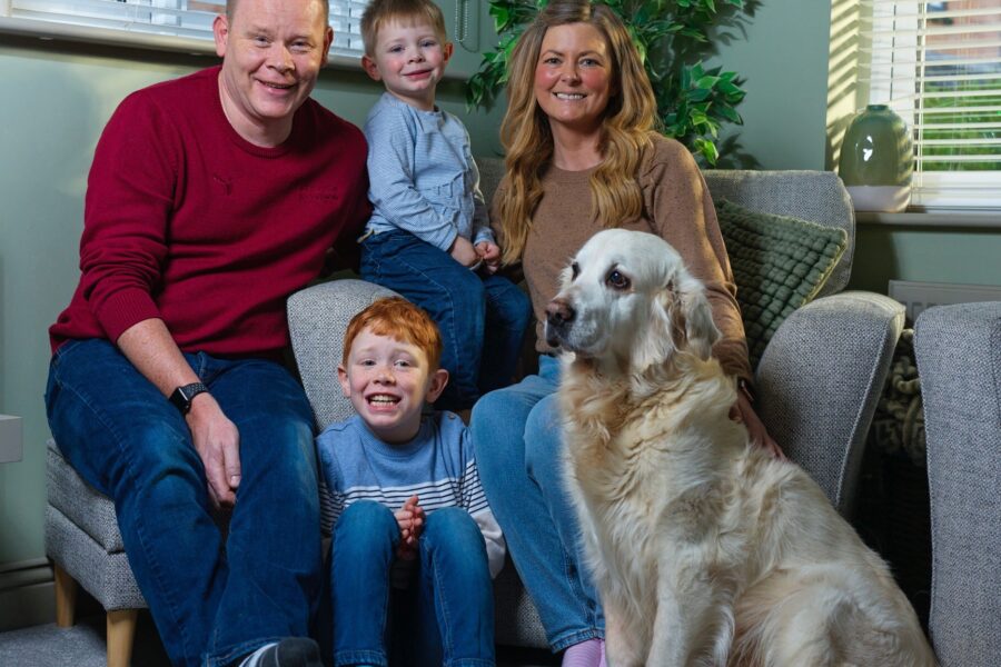 A group of people and a dog sat in a living room