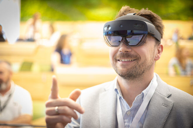 A picture of a person in a business suit wearing VR goggles.